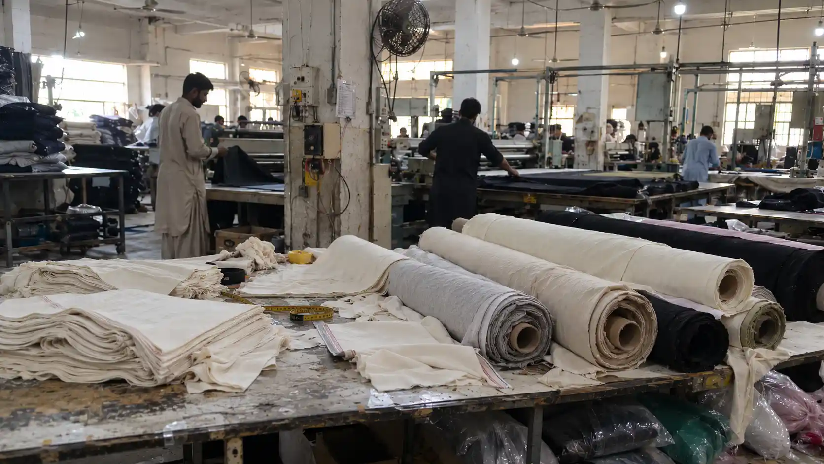 Raw organic cotton bolls and certified organic cotton knit fabric rolls in textile facility